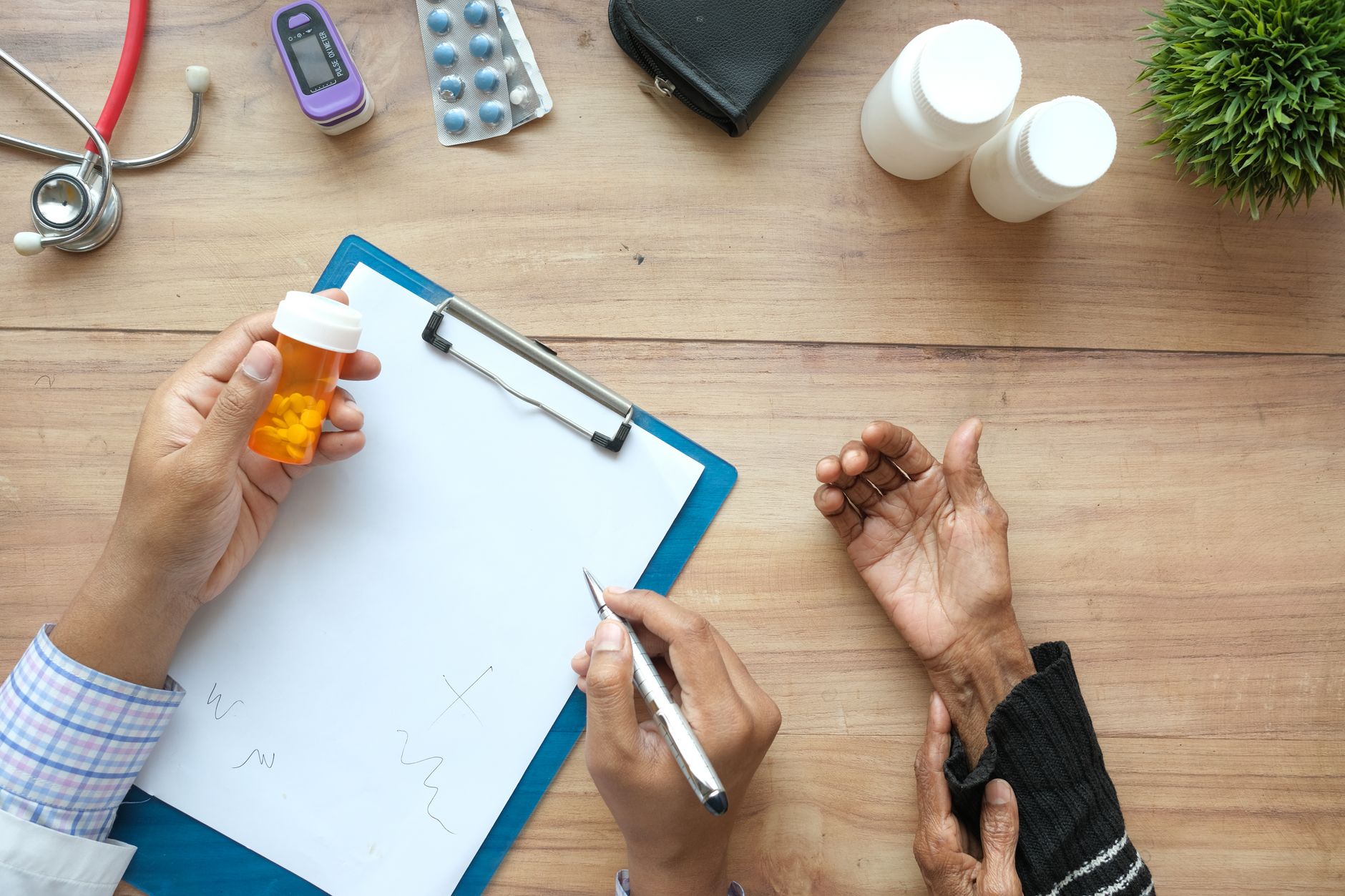 hand holding medicine over paper on desk